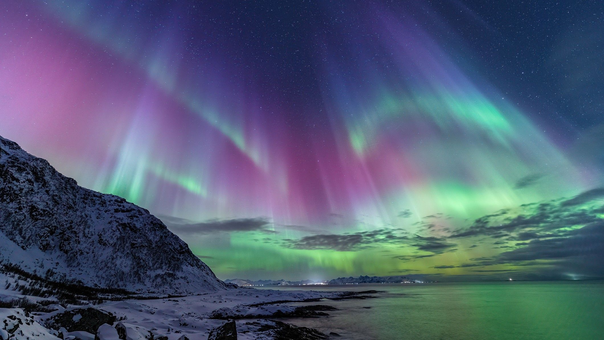 A view of the Northern Lights over snow-covered mountains