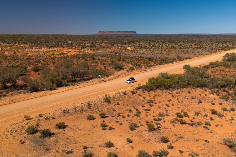 A red dirt road stretching through the remote Australian Outback